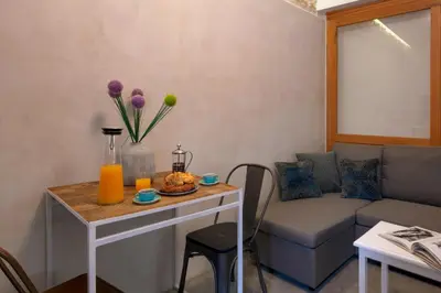a living room with a couch and a table with flowers at Koum Kapi Boutique Apartments in Chania Town