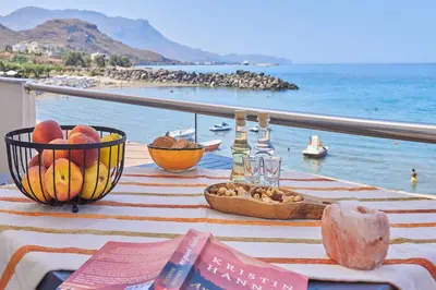a table with a basket of fruit and a view of the ocean at Seaside House in Kissamos