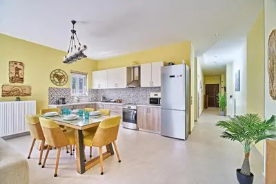 a kitchen with a table and chairs and a white refrigerator at Seaside House in Kissamos