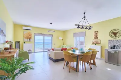 a dining room and living room with a table and chairs at Seaside House in Kissamos