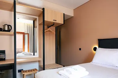 a small bedroom with a bed and a mirror at Centro Storico in Chania Town