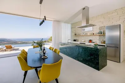 a kitchen with a dining table and yellow chairs at Ellas Residence fantastic pool heated in Kissamos