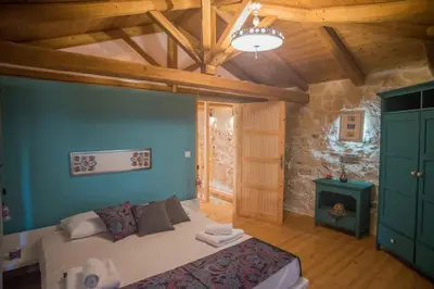 a bedroom with a bed in a room with wooden ceilings at Old stone villa in Apokoronas Villa Nostalgia Kreta in Fílippos