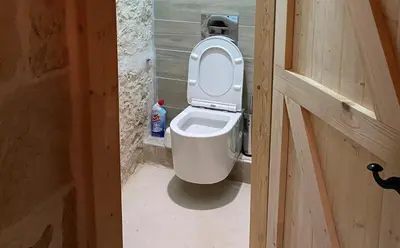 a bathroom with a toilet with the lid up at Old stone villa in Apokoronas Villa Nostalgia Kreta in Fílippos