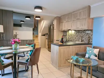 a kitchen and living room with a table and chairs at Seastar seafront villa in Kalamaki Chanion