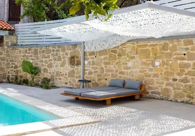 a bench with an umbrella next to a pool at Villa Evrithea in Kalleryianá