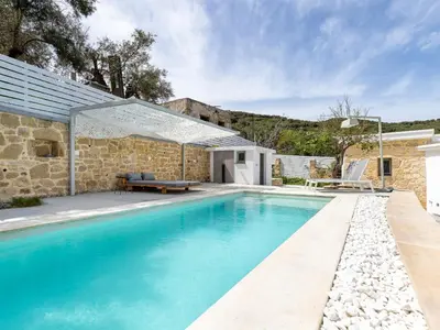 a swimming pool in front of a stone house at Villa Evrithea in Kalleryianá