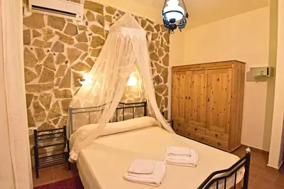 a bedroom with a bed with a mosquito net at Olive Farm in Agia Marina Nea Kydonias