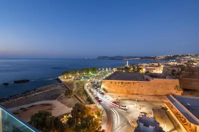 an aerial view of a city and the ocean at night at SanSal Boutique Hotel in Chania Town