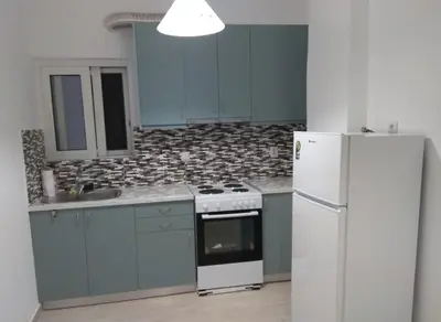 a kitchen with blue cabinets and a white refrigerator at Iris Apartment in Chania Town