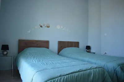 two beds in a room with a blue light at Iris Apartment in Chania Town