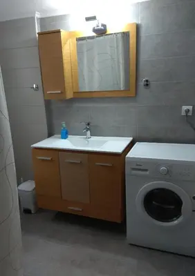a bathroom with a sink and a washing machine at Iris Apartment in Chania Town