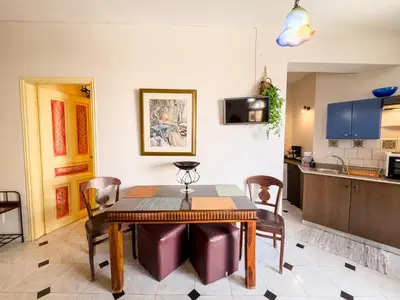 a kitchen and dining room with a table and chairs at Villa Eleni Seaside Apartments in Plataniás