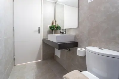a bathroom with a white toilet and a sink at Helios Residence in Chania Town
