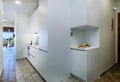a kitchen with white cabinets and a tile floor at Xenios Dias Luxury Apartments With Sea View in Kato Daratso