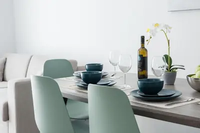 a dining room table with chairs and a bottle of wine at Casa Ntore Luxury Apartments in Chania Town