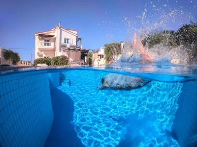a polar bear swimming in a pool with a fountain at Ifigeneia's Lavish Escape with Private Hot Tub in Kalathas