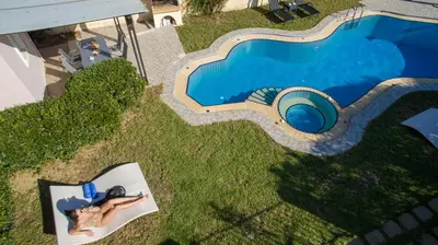an overhead view of a swimming pool with a woman laying on a chair next to at Ifigeneia's Lavish Escape with Private Hot Tub in Kalathas