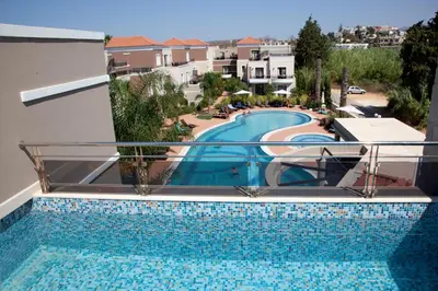 a swimming pool on the balcony of a building at Okeanis Golden Resort in Kato Daratso