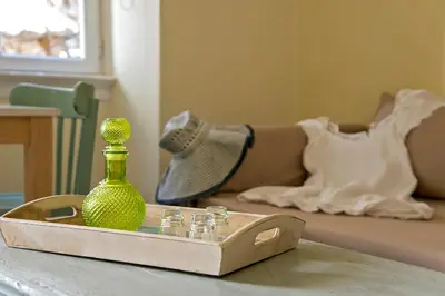a green vase sitting on a table next to a bed at Antica Casa Studios in Chania Town