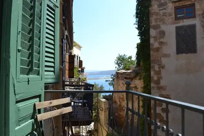 a balcony with a green door and a view of the water at Antica Casa Studios in Chania Town
