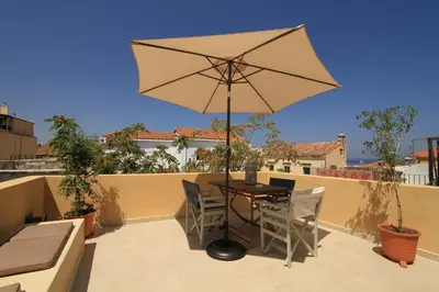 a patio with a table and an umbrella at Fagotto Art Residences in Chania Town