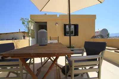 a wooden table with chairs and an umbrella on a balcony at Fagotto Art Residences in Chania Town