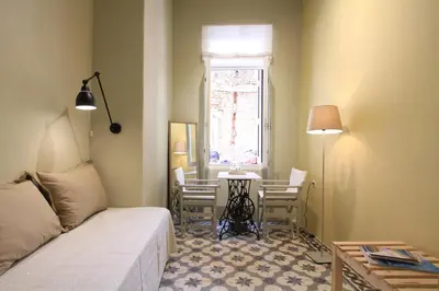 a living room with a couch and a table and a window at Fagotto Art Residences in Chania Town