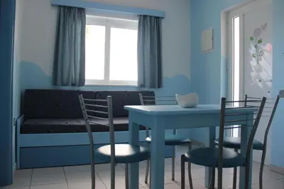 a dining room with a table and chairs and a window at Mastorakis Village in Agia Marina Nea Kydonias