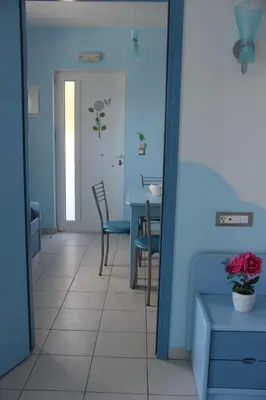 a dining room with blue walls and a table and chairs at Mastorakis Village in Agia Marina Nea Kydonias
