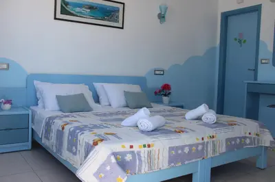 a blue bedroom with a bed with towels on it at Mastorakis Village in Agia Marina Nea Kydonias