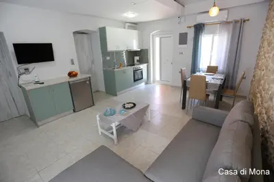 a living room and kitchen with a couch and a table at Casa di Mona in Chania Town