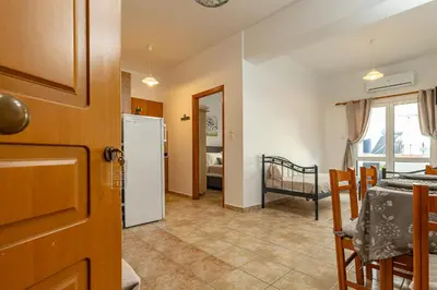 a kitchen and dining room with a table and a refrigerator at Panoramio Paleochora Apartments in Palaiochóra