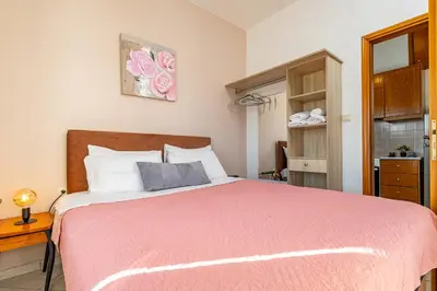 a bedroom with a large bed with a red blanket at Panoramio Paleochora Apartments in Palaiochóra
