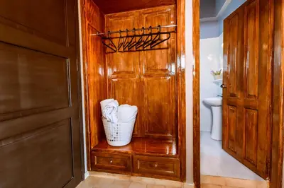a bathroom with a wooden door and a vase on a shelf at Gregory Village Sea View in Stalos