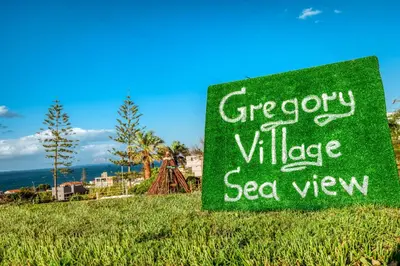 a sign for a greenery villagesea view on a hill at Gregory Village Sea View in Stalos