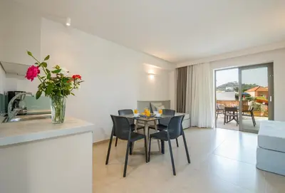 a kitchen and living room with a table and chairs at Stefan Village Hotel in Agia Marina Nea Kydonias