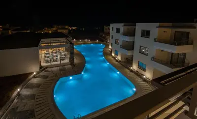 an overhead view of a swimming pool at night at Stefan Village Hotel in Agia Marina Nea Kydonias
