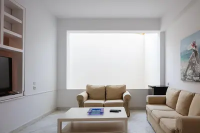 a living room with two chairs and a coffee table at Angels Villa - 8-Bedroom Estate Ideal for Groups & Families by etouri in Kambánion