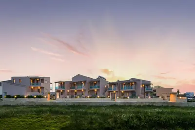 a rendering of a building at sunset at Aegean Breeze Luxury Apartments next to the sea in Maleme
