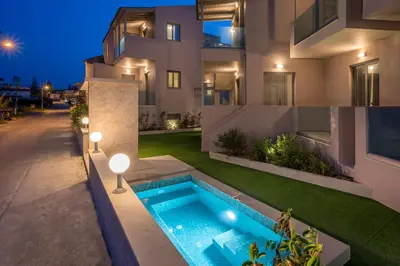 an image of a house with a swimming pool at Aegean Breeze Luxury Apartments next to the sea in Maleme