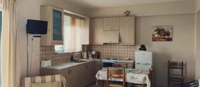 a small kitchen with a table and a refrigerator at Riza Falasarna Apartments in Falasarna