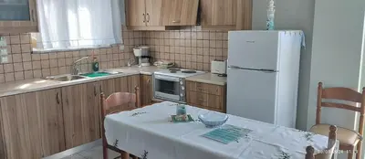 a kitchen with a table and a white refrigerator at Riza Falasarna Apartments in Falasarna