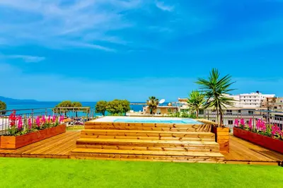 a deck with a swimming pool and some flowers at Pearl Seaside Cozy Apartments in Chania Town