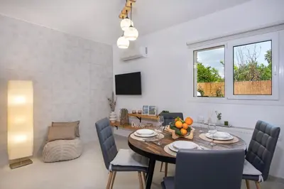 a dining room and living room with a table and chairs at Elenas Village house - Dream apt w Pool & Terrace in Alikianós