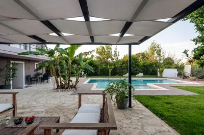 a patio with a white umbrella and a swimming pool at Elenas Home - Dream & Love apts w Private pool in Alikianós