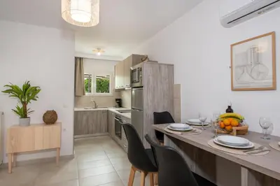 a kitchen and dining room with a table and chairs at Elenas Village House - Love apartment with Pool and Terrace in Alikianós