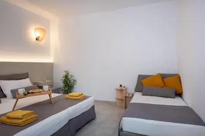 a bedroom with two beds and a table in it at Elenas Village House - Love apartment with Pool and Terrace in Alikianós