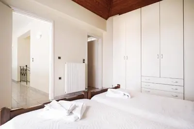 a bedroom with a white bed and a large window at Wonderful Villa in Chania with Private Pool, Panoramic Sea Views & Spacious Interiors in Agios Onoufrios