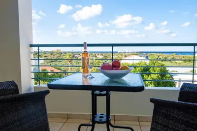 a table with a bowl of fruit on a balcony at Wonderful Villa in Chania with Private Pool, Panoramic Sea Views & Spacious Interiors in Agios Onoufrios